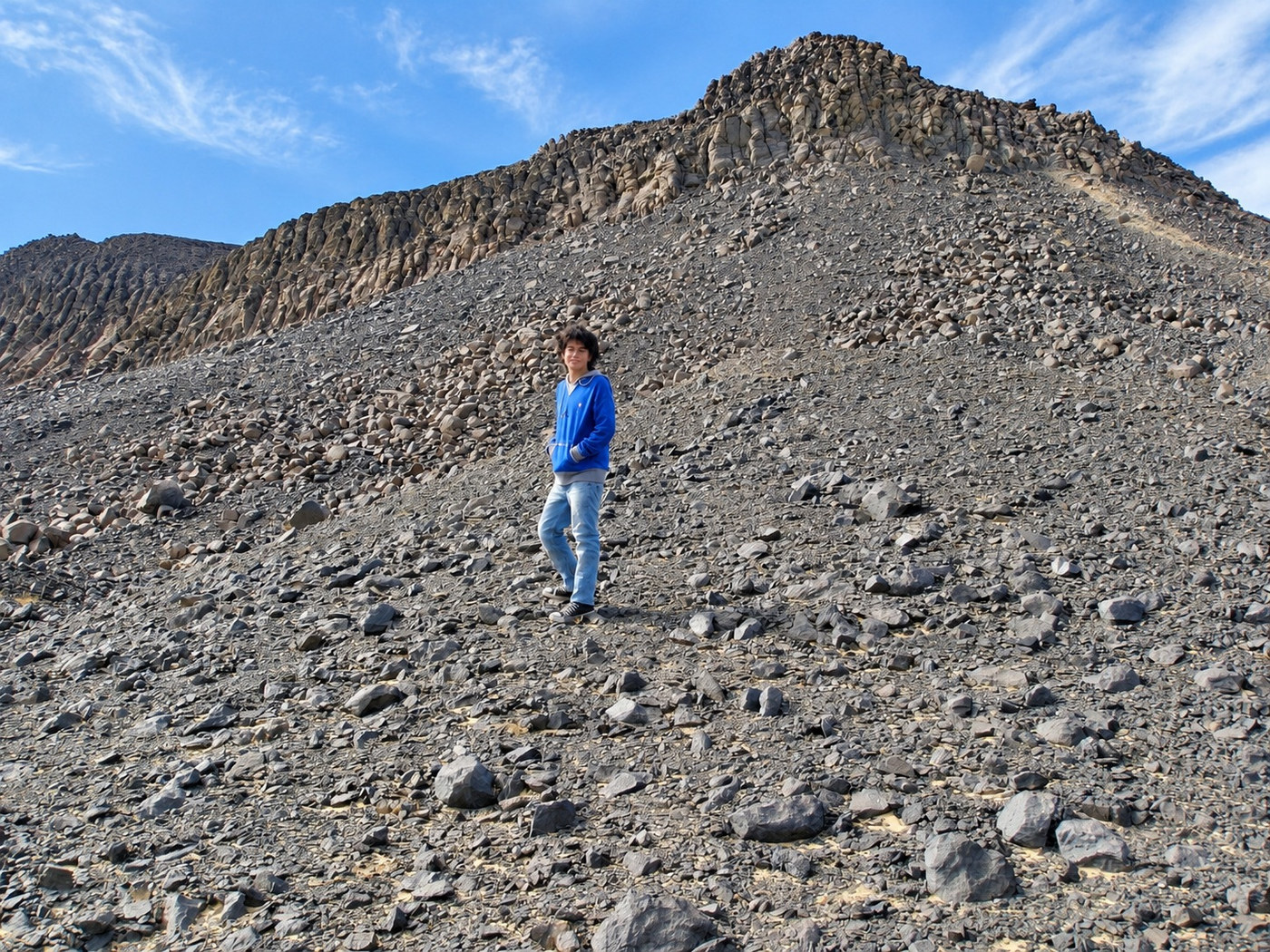 Danny de pie en una ladera de rocas negras de basalto en el Desierto Negro